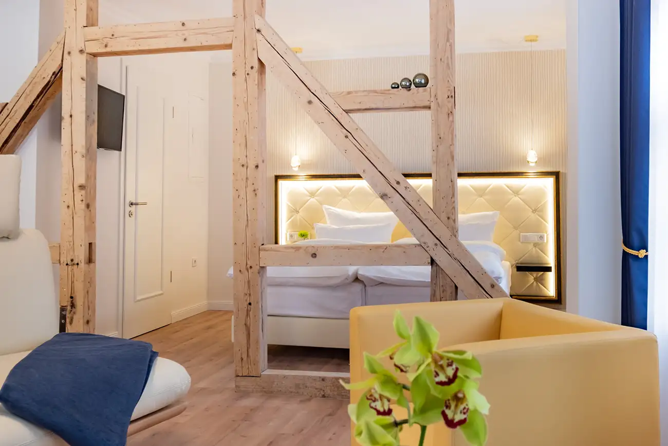 Zimmer mit separatem Schlafbereich und Holzbalken